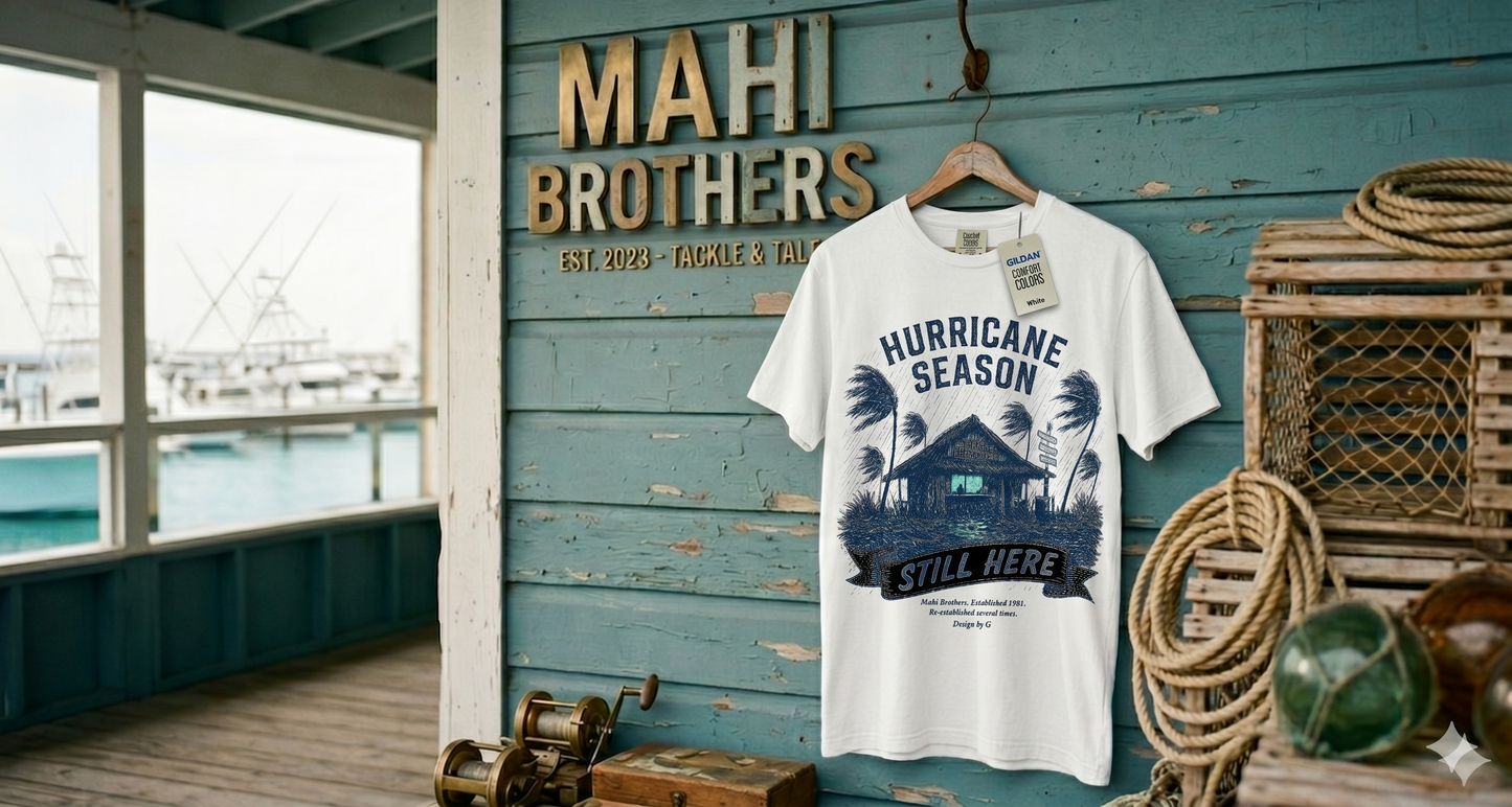 Mahi Brothers Outfitters Hurricane Season Still Here tee with weathered shack, bending palms, and a Good Times Cold Drinks Low Expectations sign